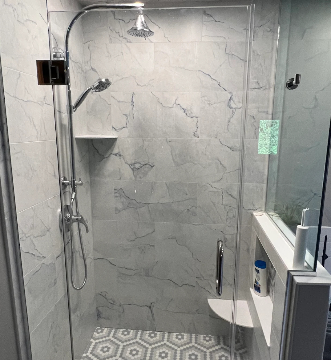 Walk-in shower with custom tile flooring, ledge, and chrome fixtures in Kenosha, WI