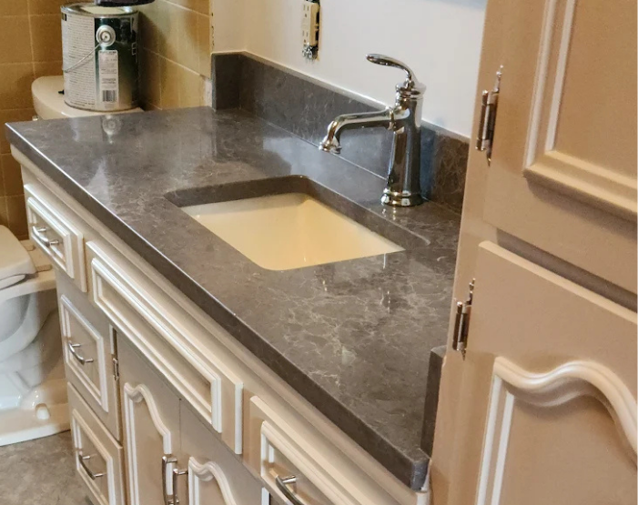 vanity with matching cabinetry and black countertops in Kenosha, WI