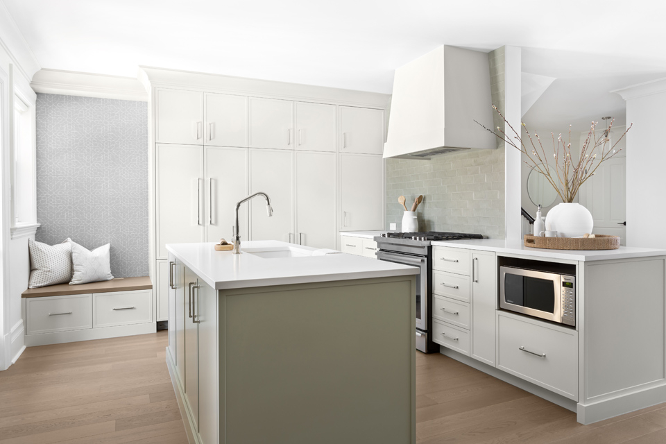 Open concept white kitchen with nook and white countertops