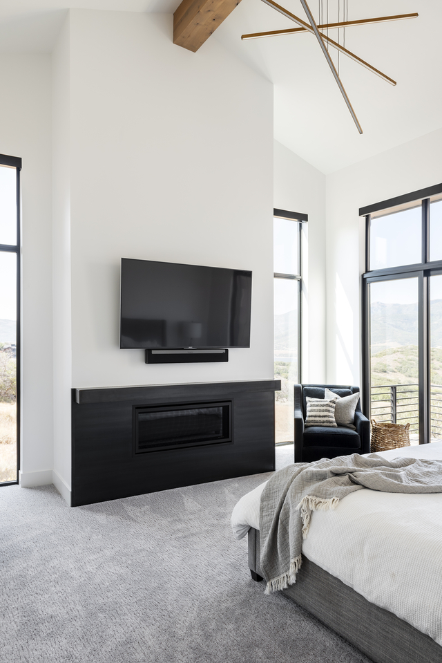 Master bedroom with gray carpet in farmhouse home